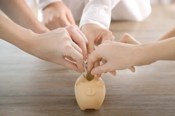 Putting coin into piggy bank — Stock Photo, Image