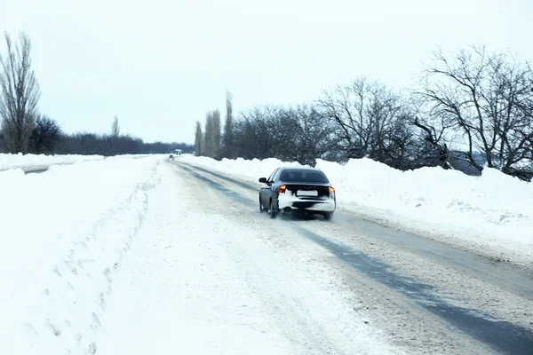 Carro dirigindo na estrada nevada — Fotografia de Stock