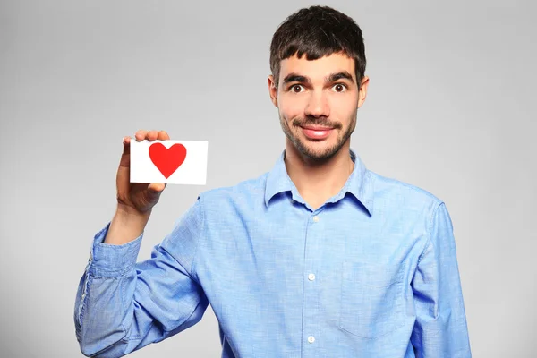 Hombre sosteniendo corazón de papel rojo —  Fotos de Stock