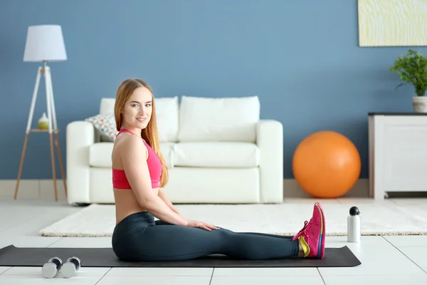 Спортсменка делает упражнения на коврике — стоковое фото