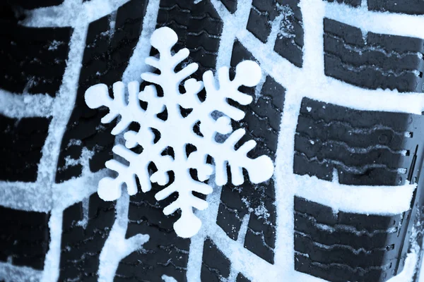 Зимові шини в снігу зі сніжинкою — стокове фото