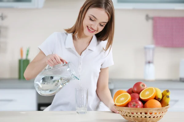 Jeune femme versant de l'eau — Photo