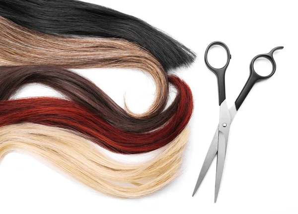 Scissors with varicolored strands of hair — Stock Photo, Image