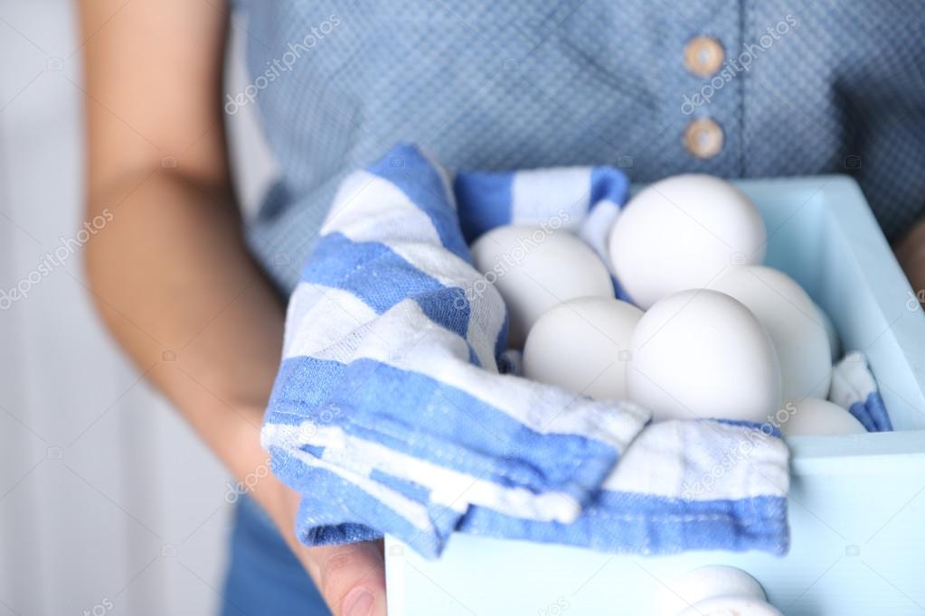 Eggs in basket in woman hands  