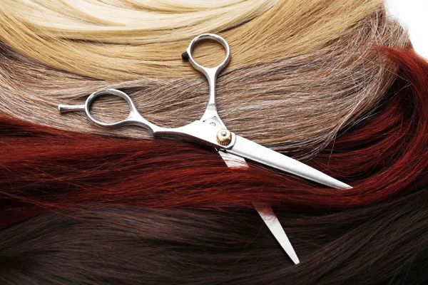 Scissors with varicolored strands of hair — Stock Photo, Image