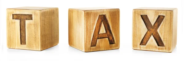 Слово TAX написано на деревянных кубиках — стоковое фото