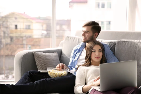 Young man and woman on sofa at home — Stock Photo, Image
