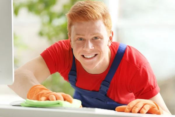 Young janitor cleaning table — Stock Photo, Image