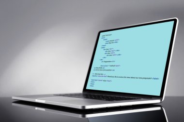 Programlama kodu üstünde laptop 