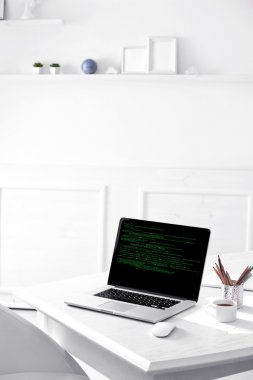 Programlama kodu üstünde laptop 