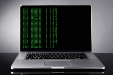 Programlama kodu üstünde laptop 