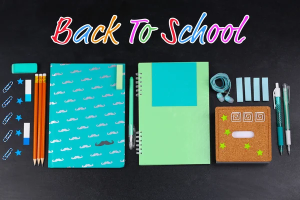 School supplies on blackboard — Stock Photo, Image