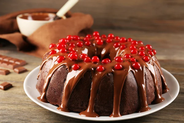 Pastel de chocolate con bayas de árbol de nieve en una mesa — Foto de Stock