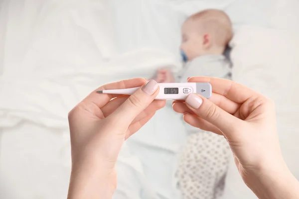 Schlafendes Baby und Hand mit Thermometer — Stockfoto