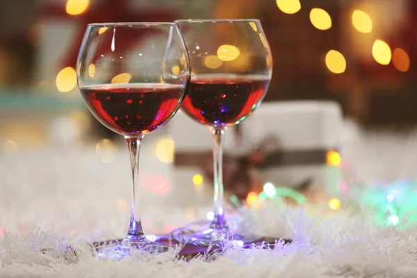 Dos copas de vino tinto sobre fondo de decoración navideña —  Fotos de Stock