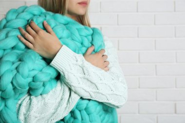 Kadın büyük örme battaniyeye sarılmış