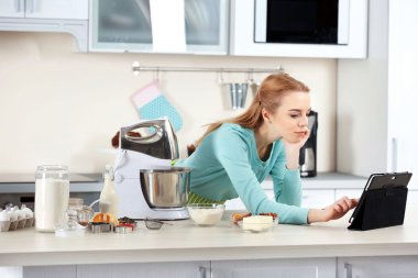 Tablet kullanan genç bir kadın.