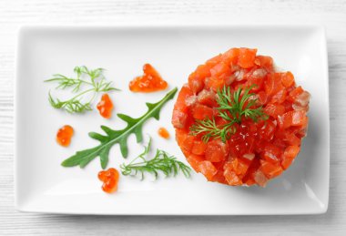 Beyaz plaka üzerinde kırmızı havyar ile lezzetli Somon tartar