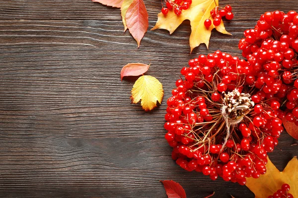 Viburnum och färgglada löv på träbord — Stockfoto