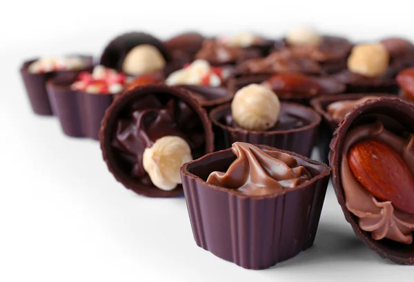 Deliziose caramelle al cioccolato su sfondo bianco, da vicino — Foto Stock