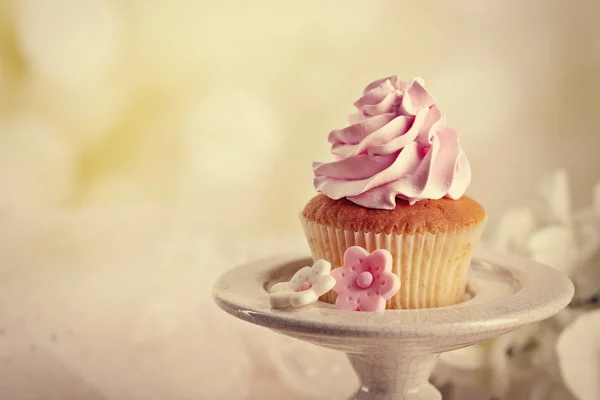 Tasty cupcake on stand, on light background — Stock Photo, Image