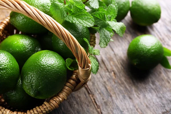 Limas con menta en canasta de mimbre —  Fotos de Stock