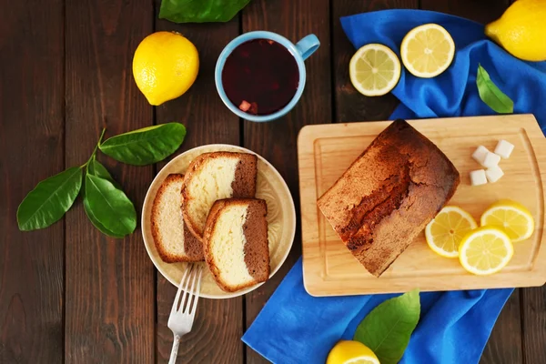 Delicioso pan de pastel dulce con limones en la mesa de madera, vista superior —  Fotos de Stock