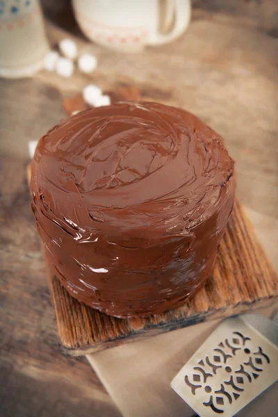 Gâteau au chocolat avec lame sur fond de planches en bois — Photo