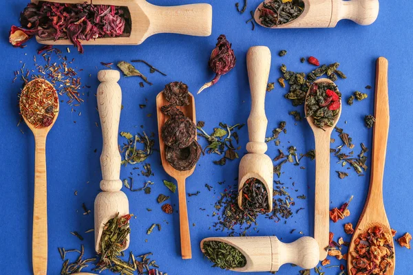 Los diferentes tipos de té que se presentan en las cucharas y cucharas de madera, vista superior — Foto de Stock