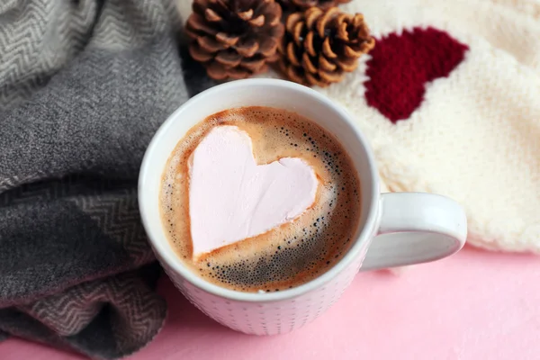 Fehérmályva szív és meleg ruhát, rózsaszín háttér, forró cappuccino csésze közelről — Stock Fotó