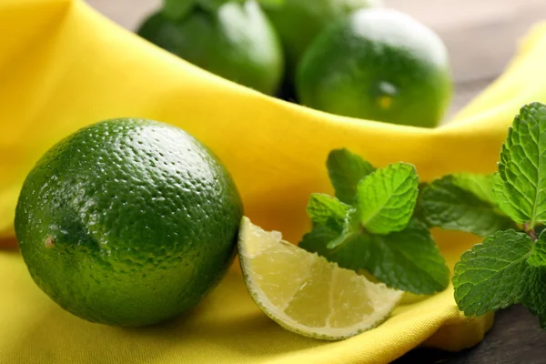 Limette fresche su tovagliolo giallo — Foto Stock