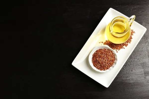 Semillas de lino con aceite sobre mesa de madera — Foto de Stock