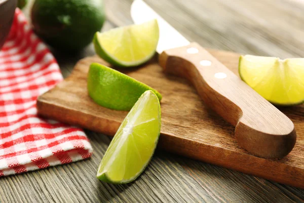 Fresh limes on cutting board — Stock Photo, Image