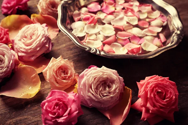Rosa y amarillo pétalos de rosa en tazón de plata — Foto de Stock