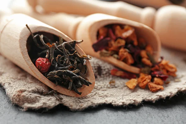 Ποικιλία από τσάι στο ξύλινο Απαγωγοί σε λινό ύφασμα και μαύρη επιφάνεια, κοντινό πλάνο — Φωτογραφία Αρχείου