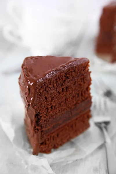 Un pedazo de pastel de chocolate con tenedores sobre fondo de mesa de madera, primer plano — Foto de Stock