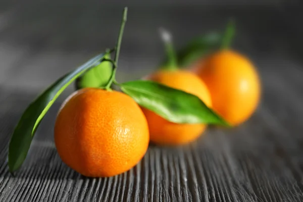 Fresh tangerines with leaves on wooden table, closeup — Stock Photo, Image
