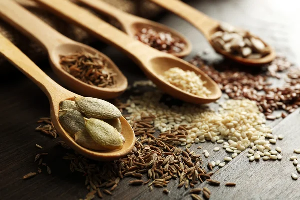 Various seeds in wooden spoons on table, closeup — Stock Photo, Image