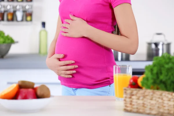 Mujer embarazada en la cocina — Foto de Stock