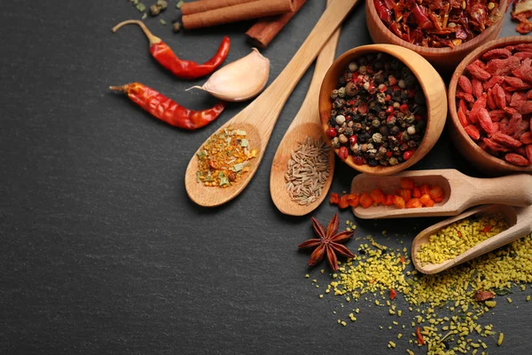 Diverse kryddor på svart bord bakgrund — Stockfoto