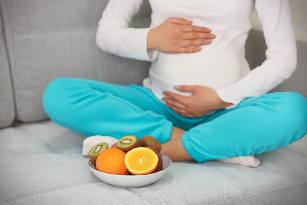 Mujer embarazada con plato de frutas — Foto de Stock