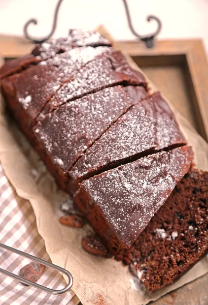 Chocolade cake met slagroom gesneden en bloemsuiker op een dienblad — Stockfoto