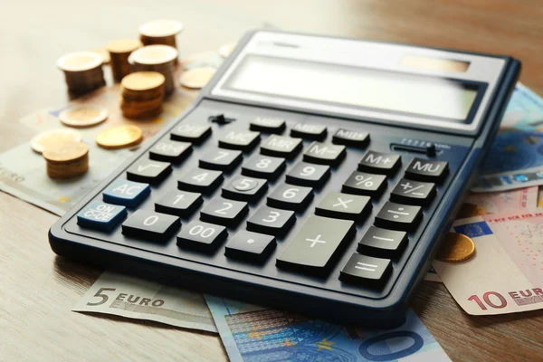 Calculator with banknotes and coins — Stock Photo, Image