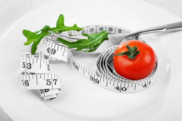 Cherry tomato, arugula and measuring tape — Stock Photo, Image