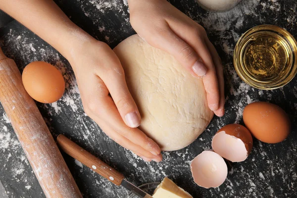 Manos femeninas sosteniendo la masa — Foto de Stock