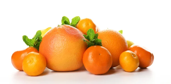 Куча смешанных цитрусовых фруктов, включая грейпфруты, апельсины, лимоны, клементины, мандарины с мятными веточками, выделенными на белом фоне, крупным планом — стоковое фото