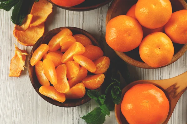 Mandarinenstücke auf hellem Holztisch — Stockfoto