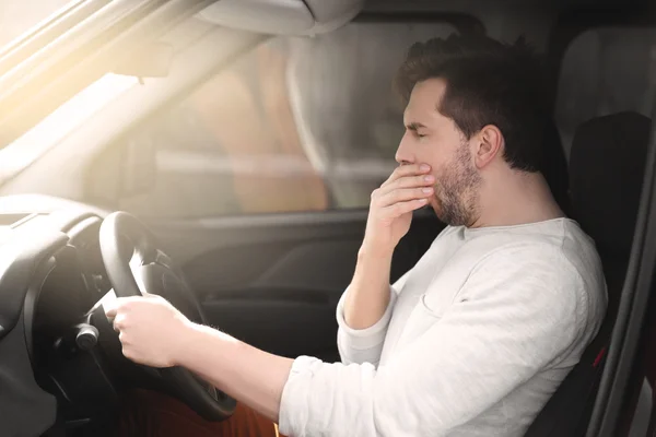 Tired man driving car.