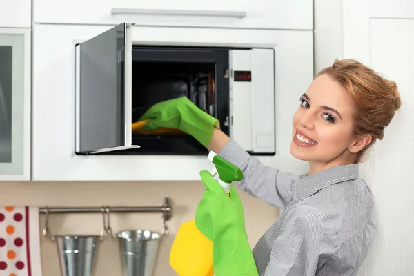 Mulher limpeza microondas — Fotografia de Stock