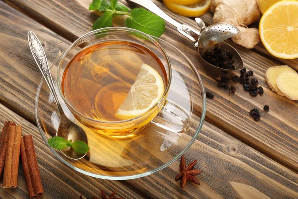 Cup of tea with ginger and cinnamon on wooden background — Stock Photo, Image